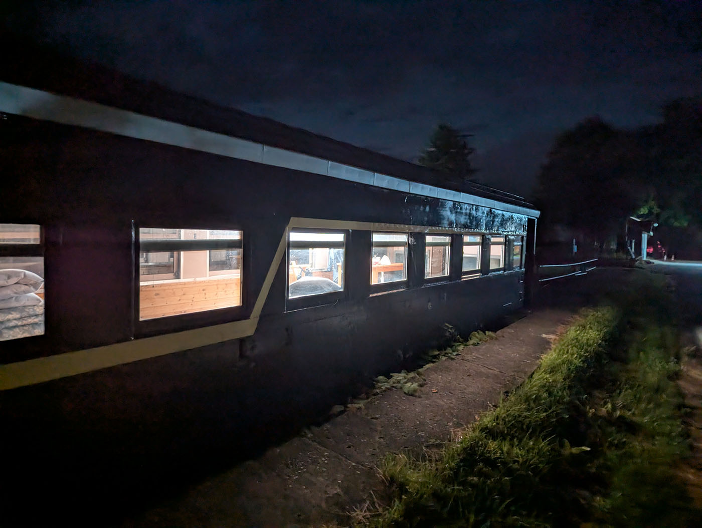 北海道むかわ町の富内銀河ステーション。夜の保存客車から温かな灯りが漏れ、静まり返った廃線ホームに浮かび上がる情景。