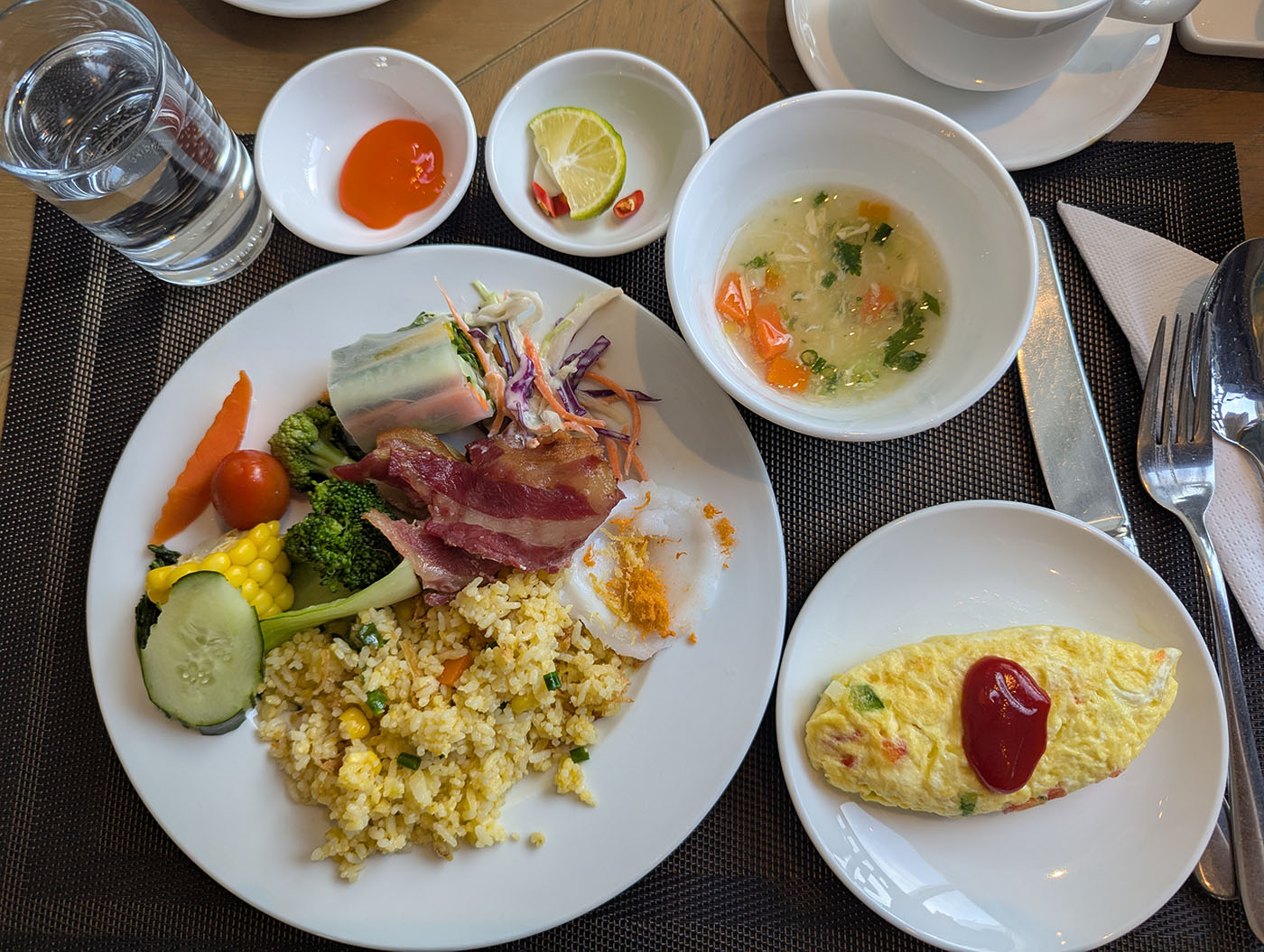 ベトナム・ダナンのホテルで食べた朝食プレート。オムレツ、チャーハン、ベーコン、生春巻き、スープなどが並んでいる。