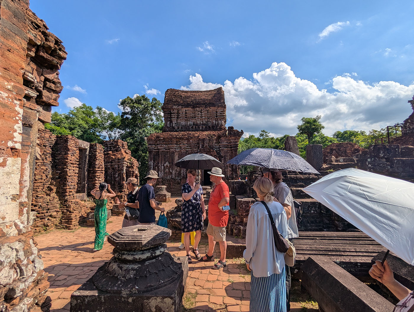炎天下のミーソン遺跡。観光客が日傘や帽子で強い日差しを避けながら見学している