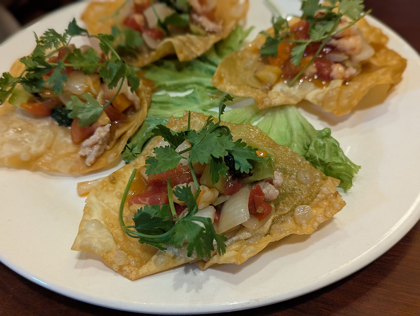 パリッと揚げたワンタンの上に具材をのせた前菜料理