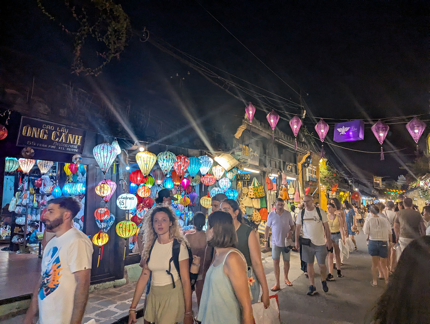 ホイアンの夜市を歩く観光客と、軒先に並ぶ色とりどりのランタン