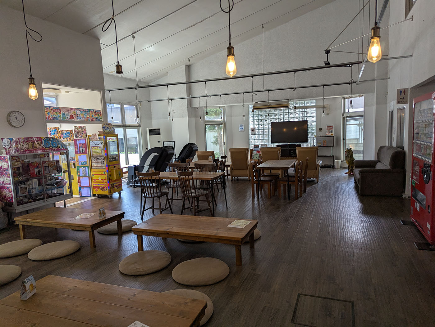  広々とした館内の休憩スペース。低めのテーブル席やリクライニングチェアも並ぶ。