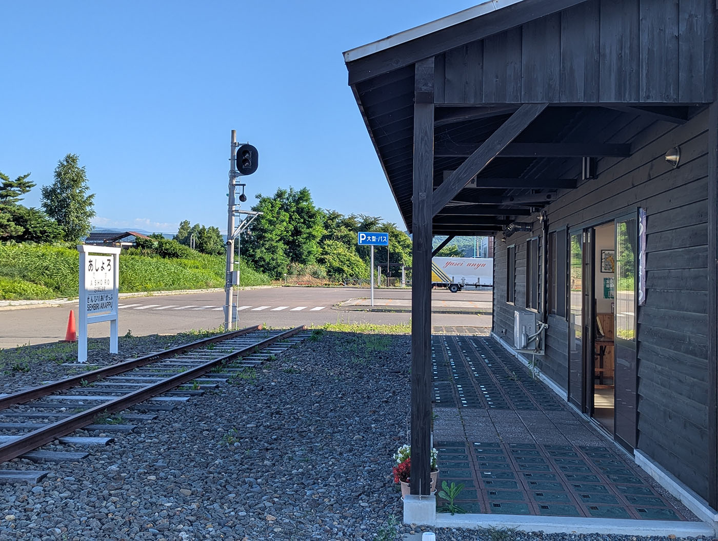 旧足寄駅舎のホーム跡と駅前に整然と並ぶ足形タイル。駅名標や信号機が残り、かつての鉄道の面影を伝えている。