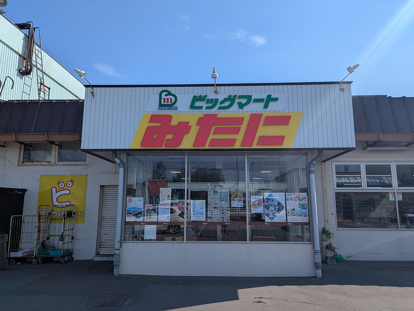 斜里町にある地元スーパー「ビッグマートみたに」の外観。白い建物に大きな黄色と赤の看板が目立つ。