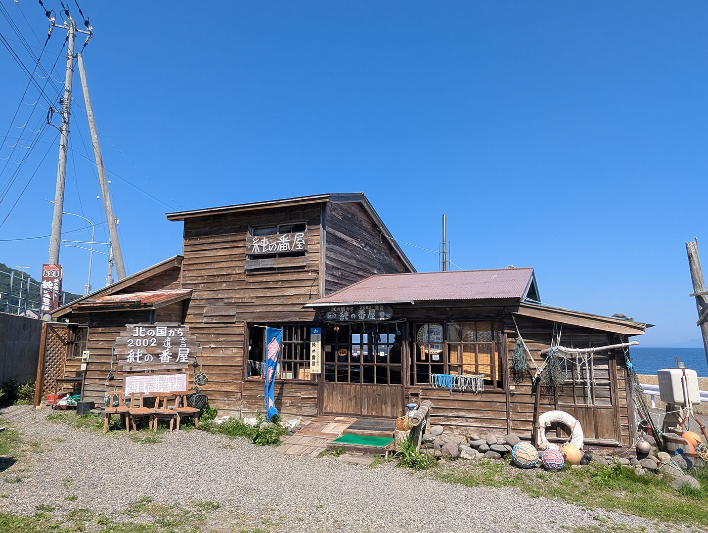 北の国から2002遺言の舞台を再現した「純の番屋」。木造の外壁と漁具が並び、羅臼の港町らしい雰囲気が漂う。