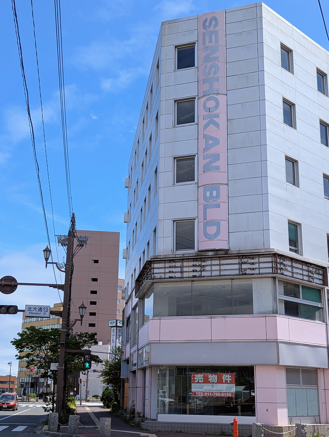 釧路駅前に立つSENSHOKANビル。売り物件の張り紙が掲示され、地方都市の変化を感じさせる建物。
