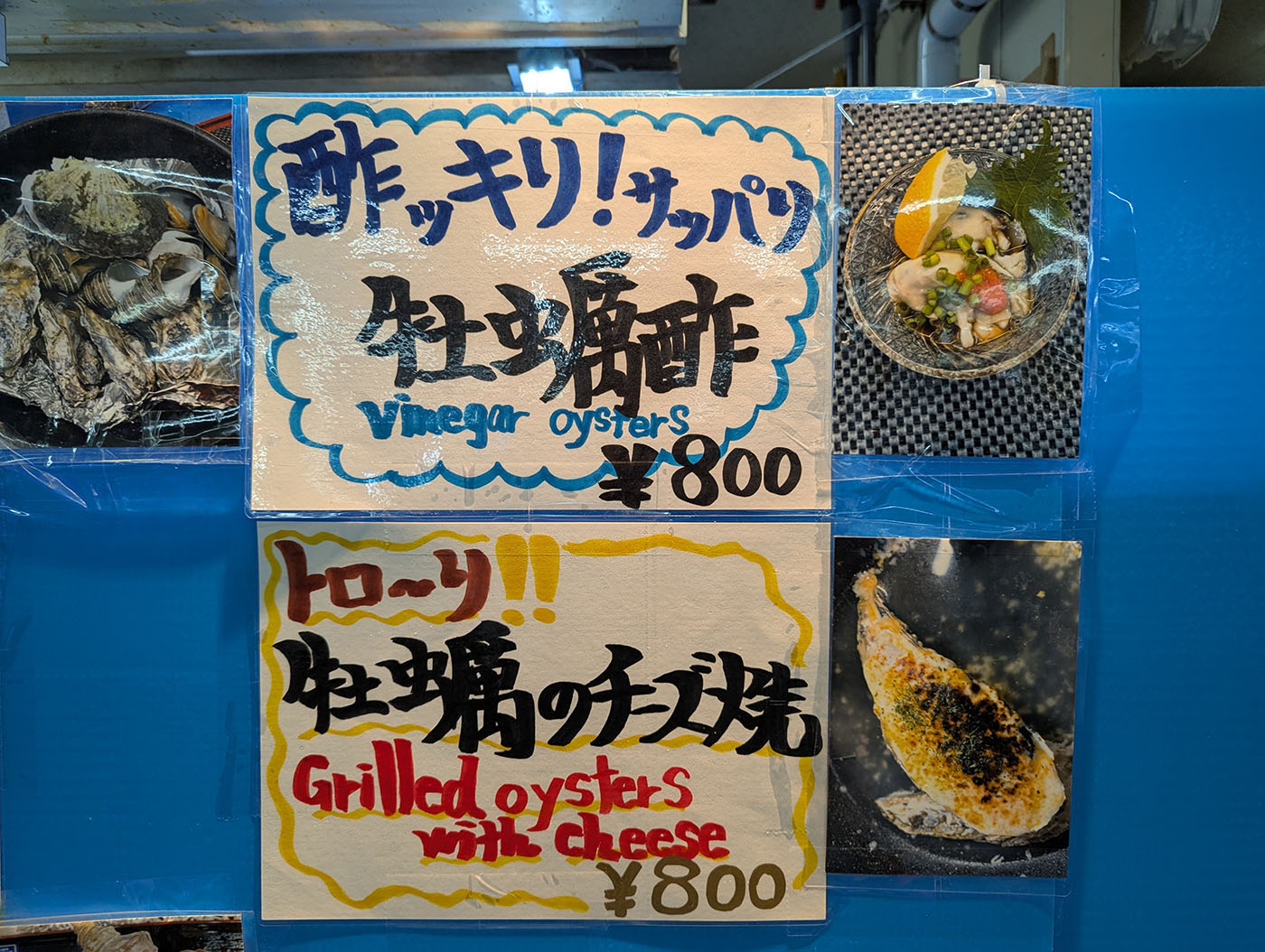 和商市場内の牡蠣料理メニュー看板。酢牡蠣と牡蠣のチーズ焼きが各800円で提供されている。