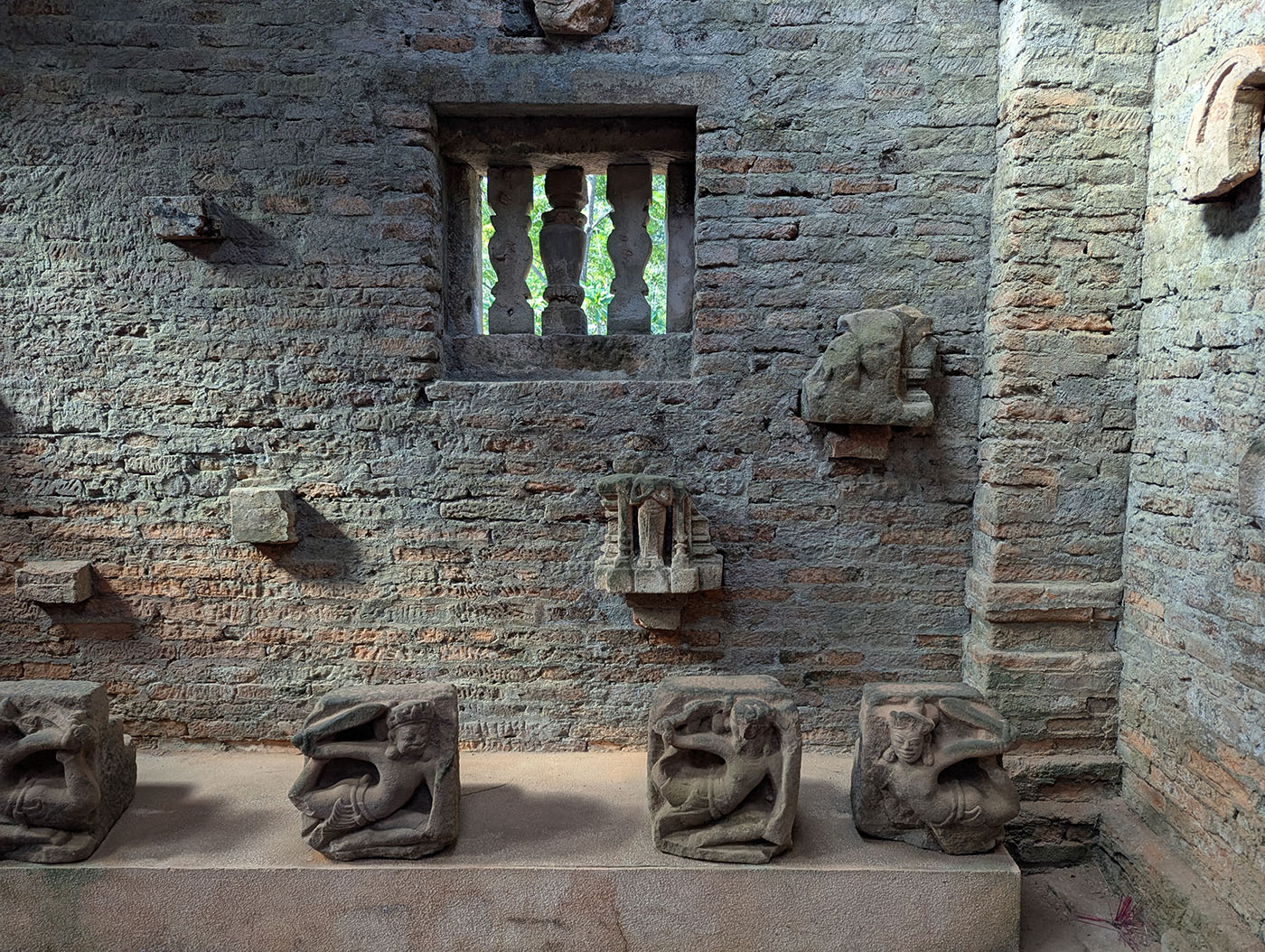 ミーソン遺跡のレンガ壁と展示された石彫の装飾片