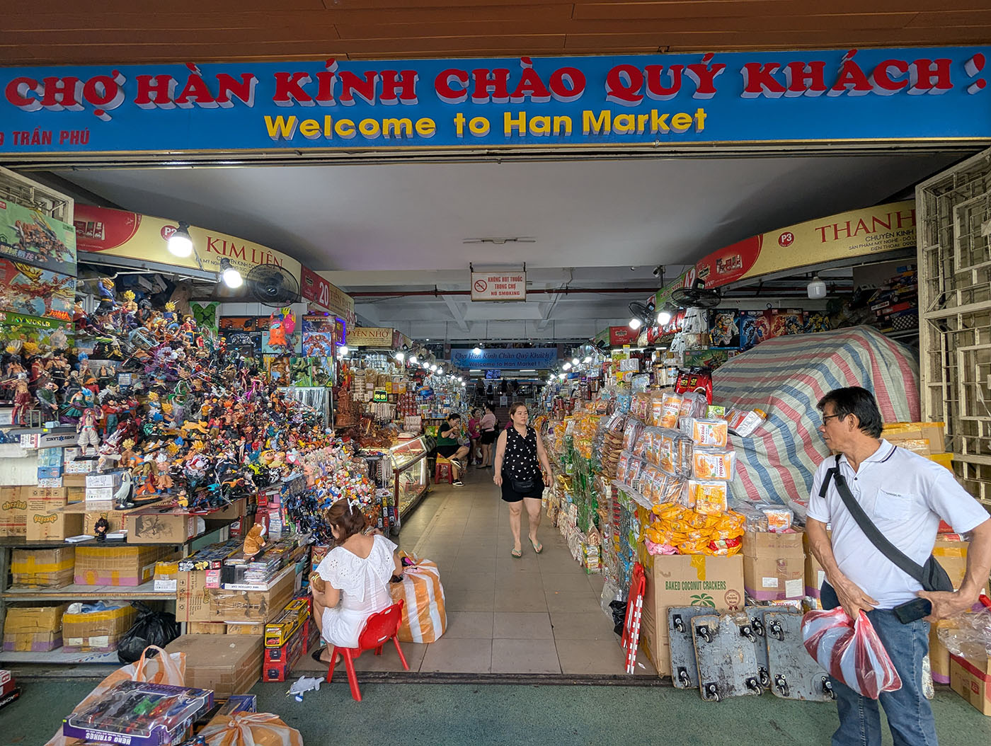 ハン市場の入口から中を見た様子。両脇にお菓子や雑貨が積まれ、観光客が歩いている