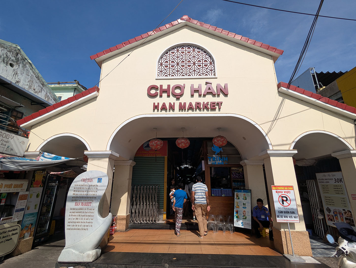 青空の下、ハン市場の正面入口に立つ観光客