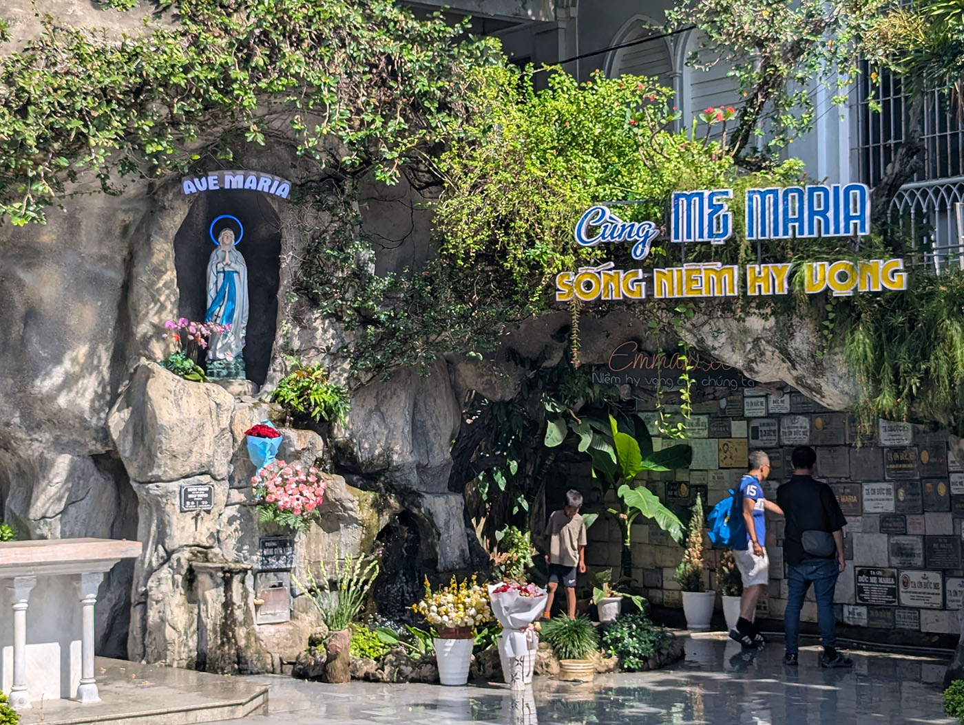 ダナン大聖堂の敷地内にある岩窟のマリア像と、祈りを捧げる人々