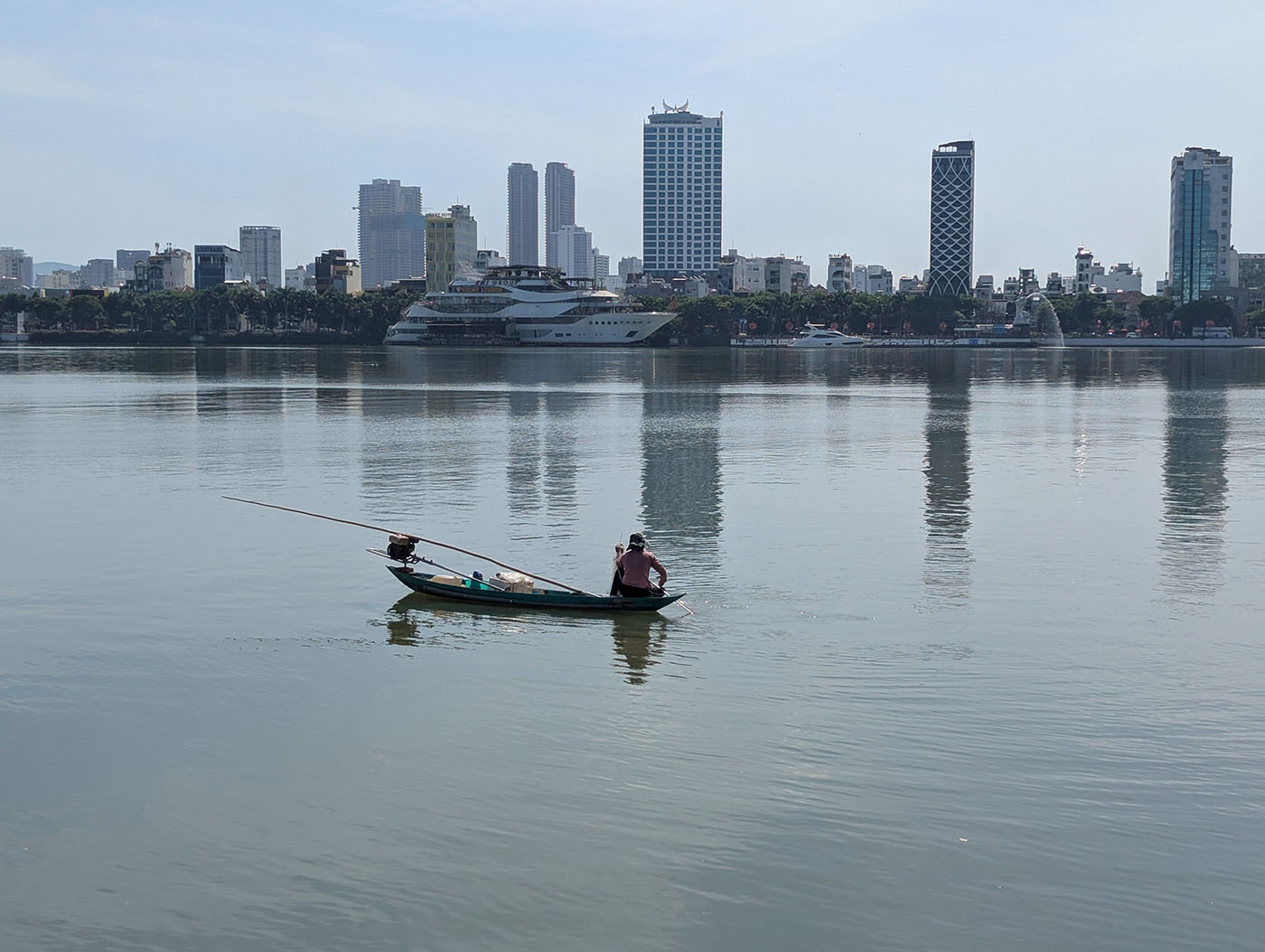 ハン川に浮かぶ小舟と、その向こうに立ち並ぶ高層ビル群