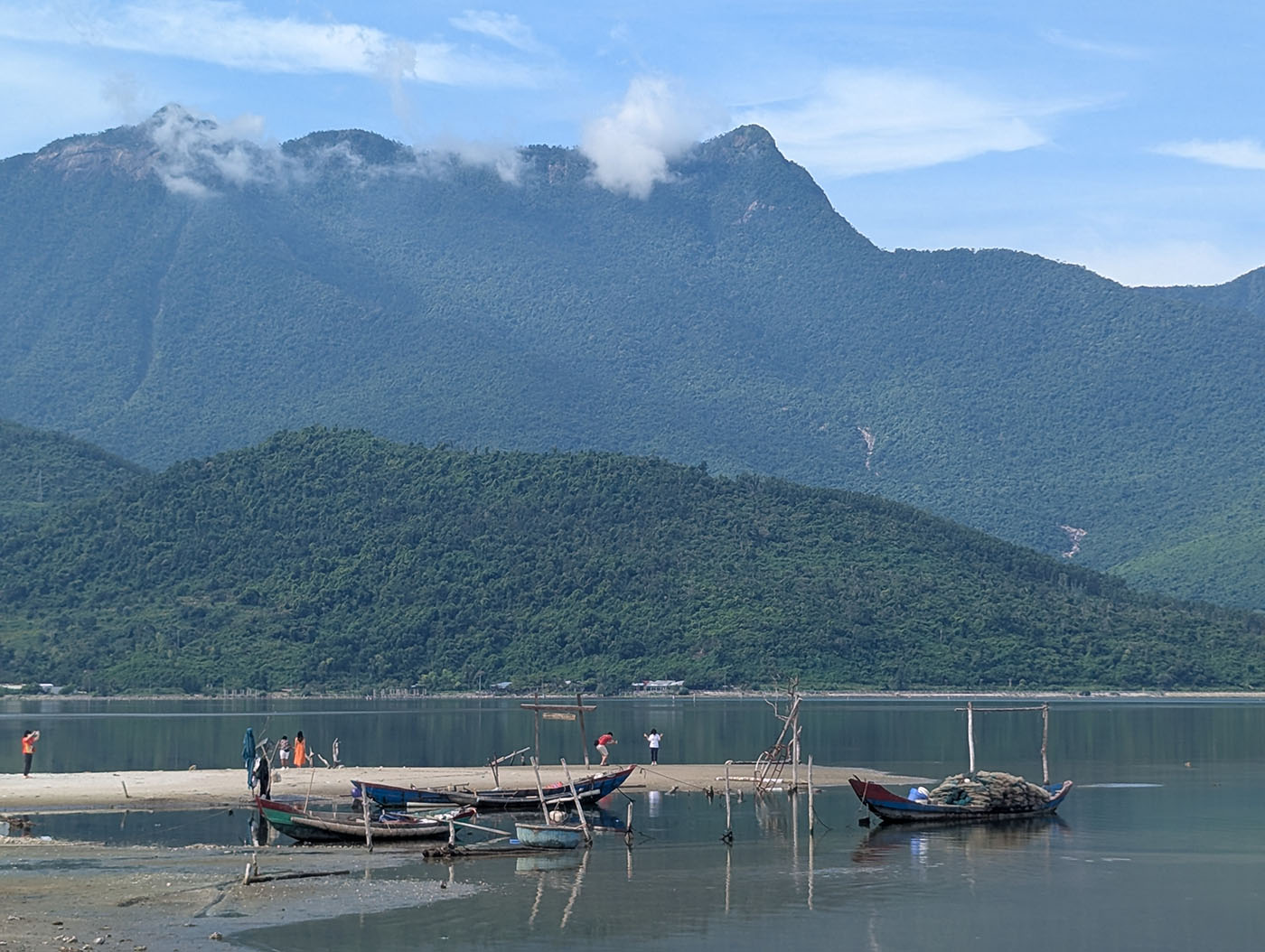 途中休憩で立ち寄ったランコー湾の静かな風景。青々とした山並みを背景に、小舟が穏やかな水面に浮かんでいる。