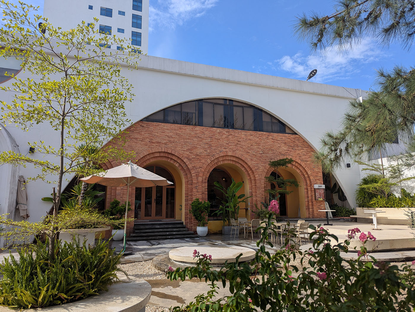 Login Coffeeの外観。レンガのアーチが印象的な入口と青空