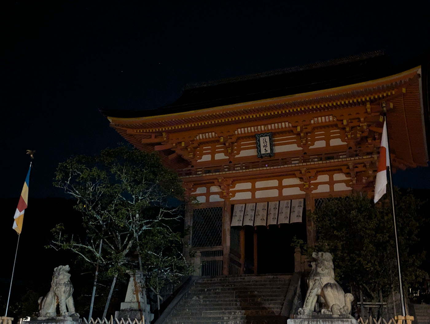 夜の清水寺仁王門。灯りに浮かぶ朱色の門と狛犬が静寂の中に佇む。