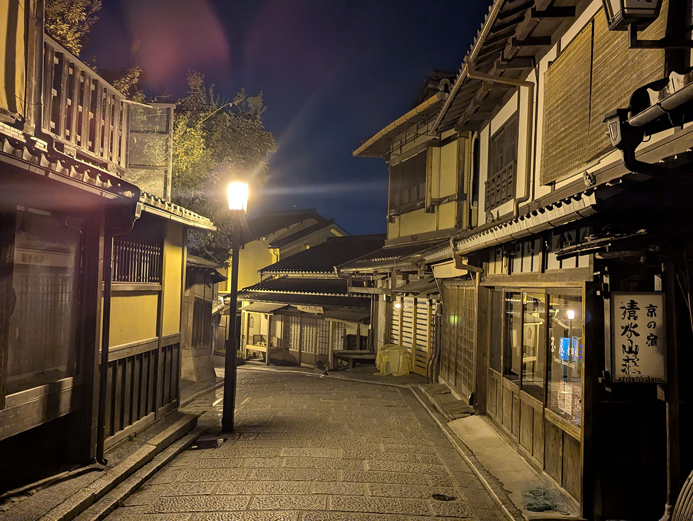 夜の清水坂。黄灯りに照らされた町家が並び、静まり返った京都の路地が続く。