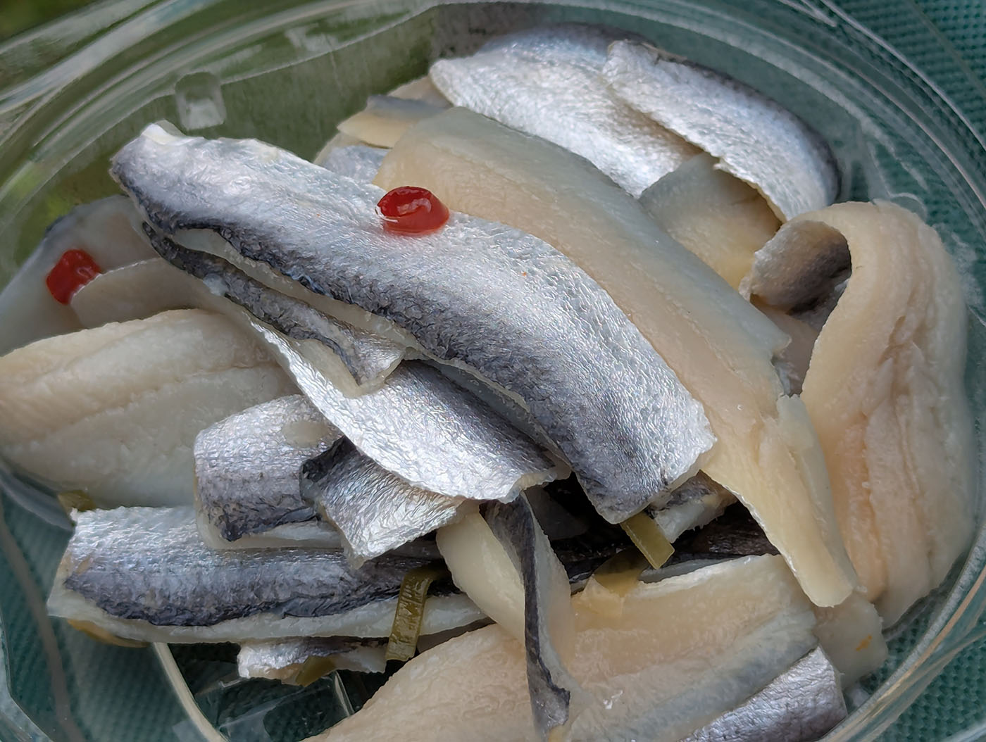 銀色に輝くニシンの酢漬け。昆布と赤唐辛子が添えられ、さっぱりとした酸味が広がる。