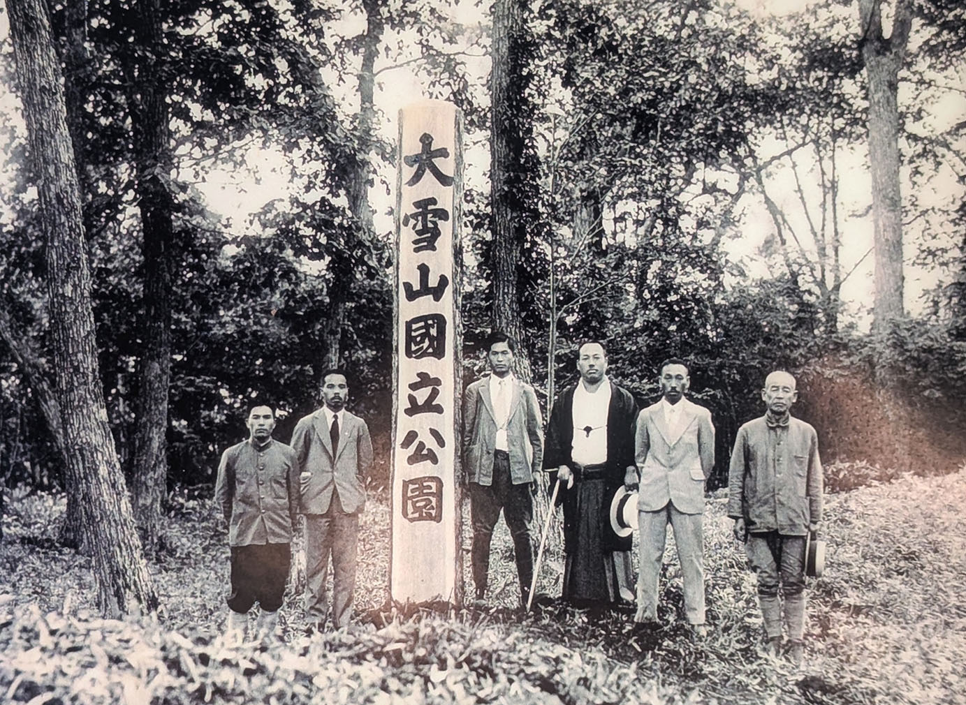 昭和9年、大雪山国立公園の指定時に記念撮影する男性たちと記念標柱