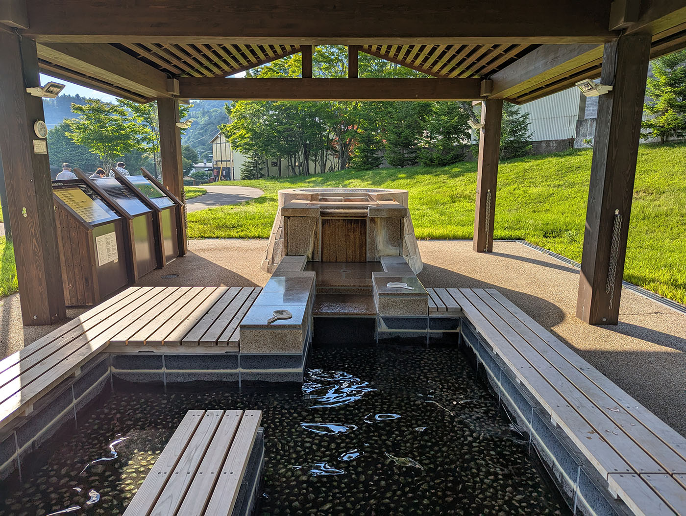 糠平温泉郷の足湯施設。木造の屋根付きで、複数のベンチが囲むように設置されている。