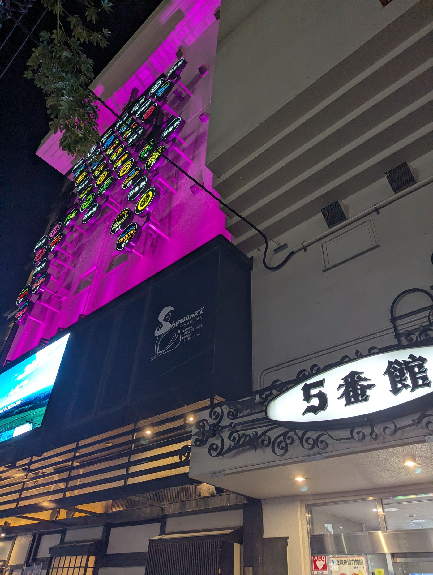 夜の帯広駅北側に建つ5番館の外観。ネオン看板が連なり、スナックや飲食店が入る帯広のランドマーク的なビルがライトアップされている。