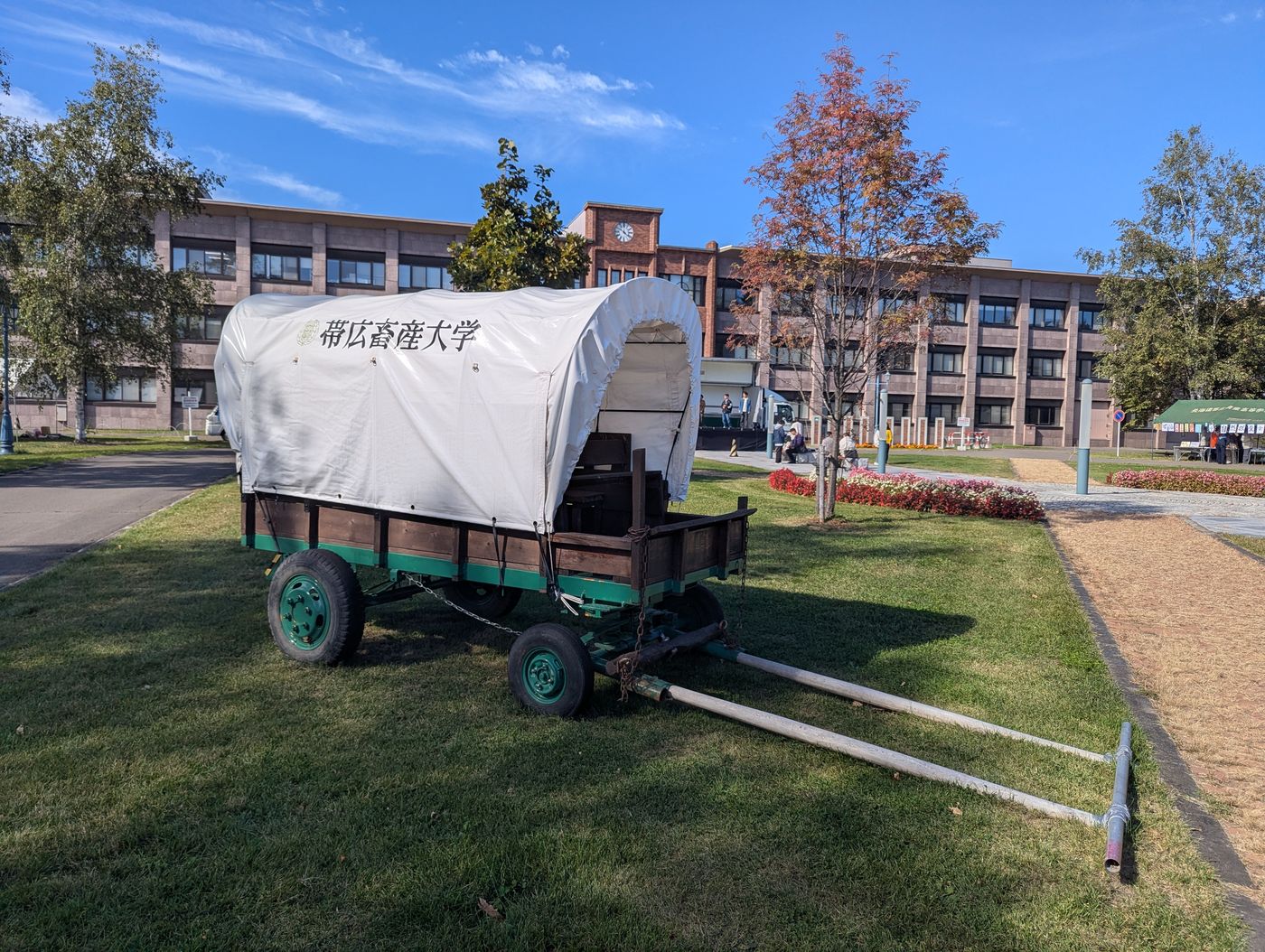 帯広畜産大学の構内に展示されている幌馬車と本館校舎