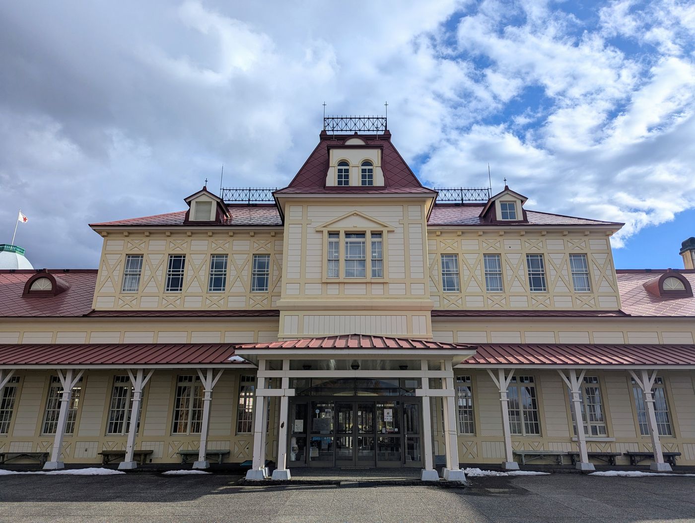 北海道開拓の村の正面に建つ、赤い屋根と装飾が特徴的な洋風建築の外観