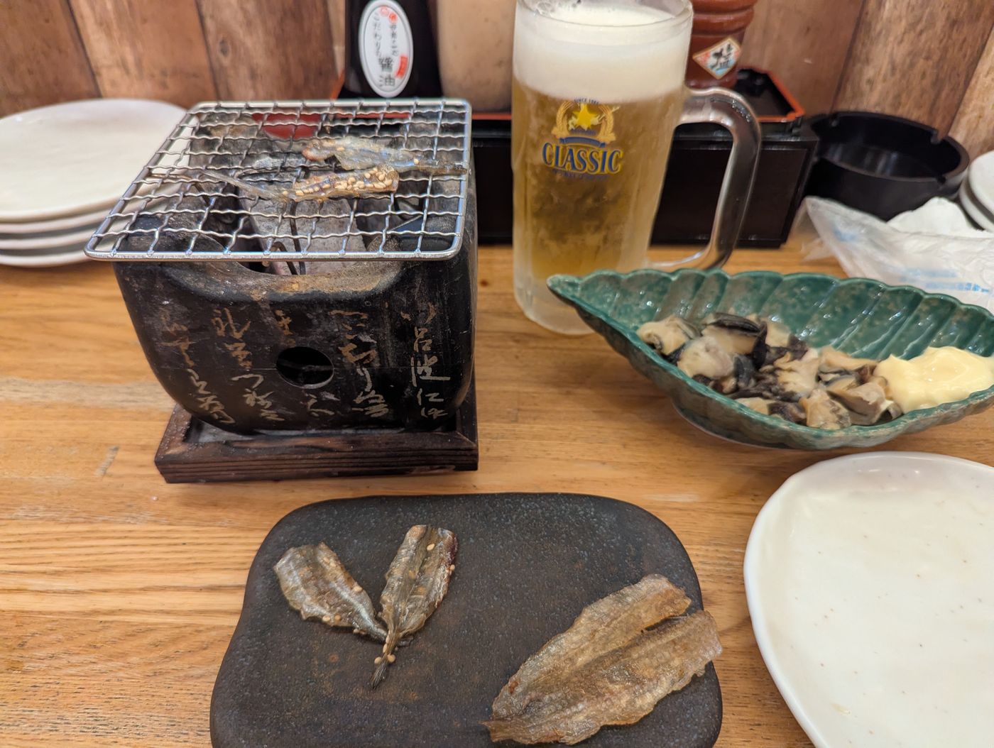 帯広駅前の炉端居酒屋で、小さな炭火コンロとクラシックビールを前にしたカウンター席の様子