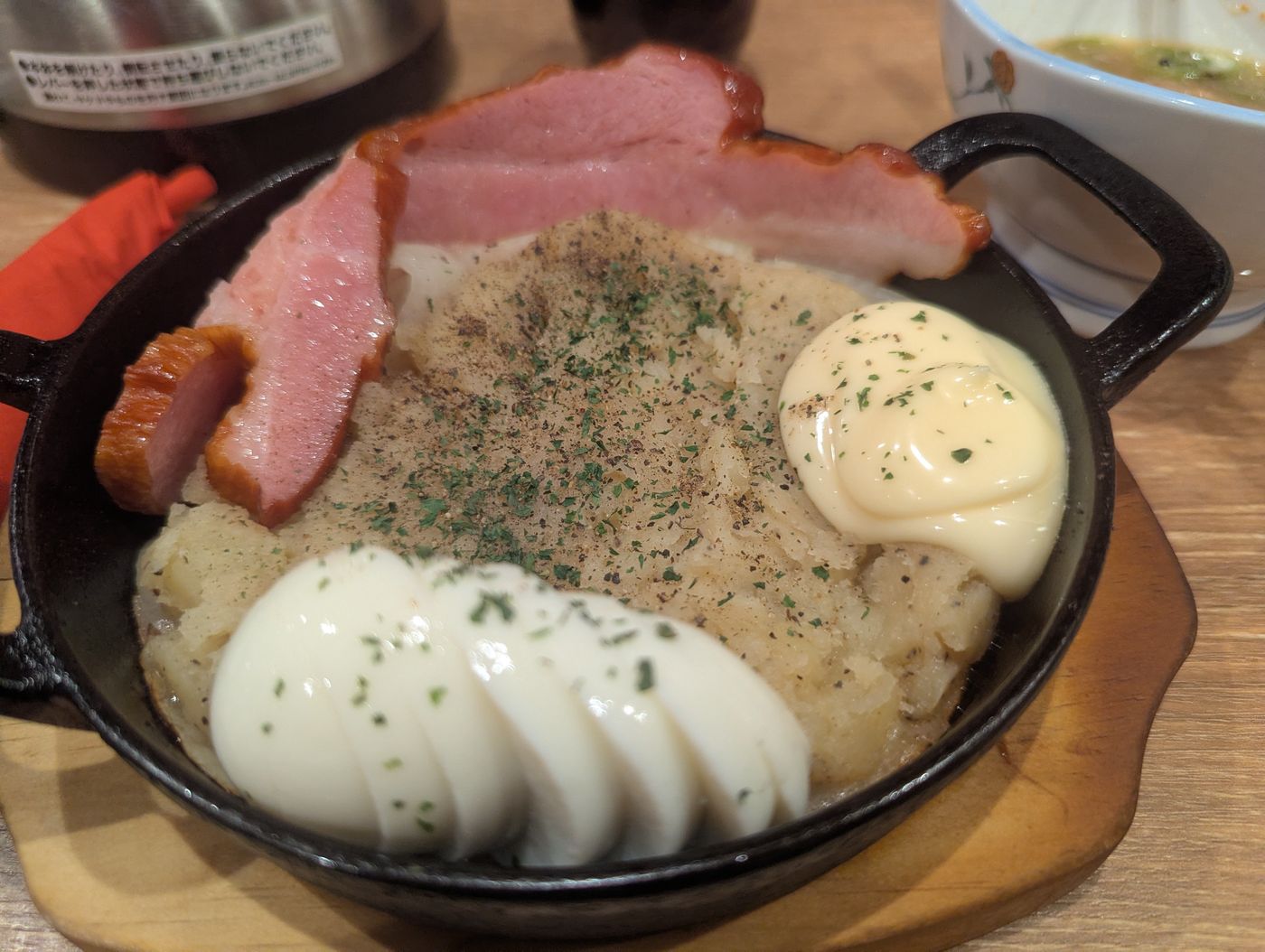 帯広とかち晴ルの名物ポテトサラダ 厚切りベーコンとゆで卵をのせた鉄鍋仕立て