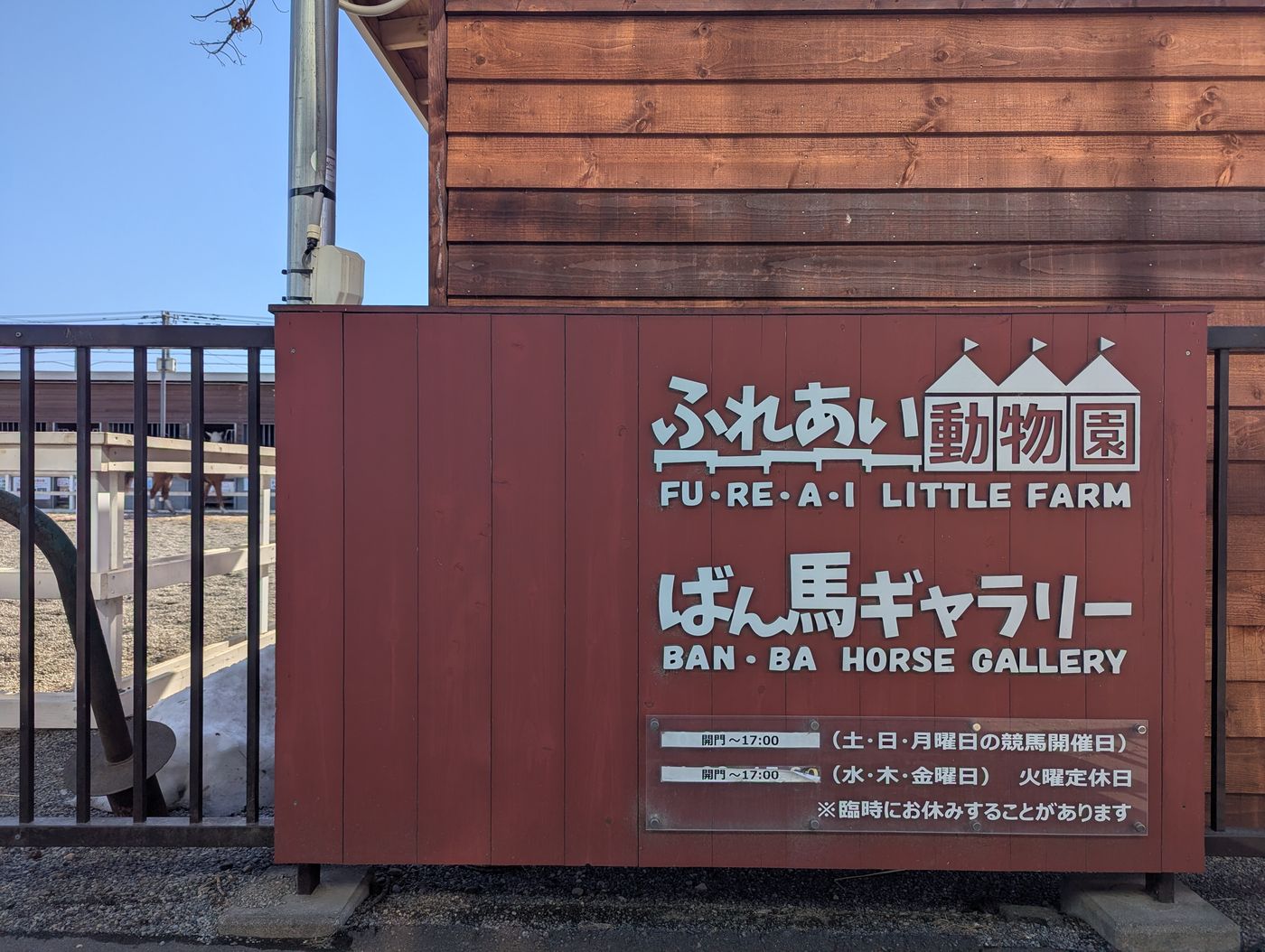ふれあい動物園とばん馬ギャラリーの案内看板。営業時間や休園日の表示が見える