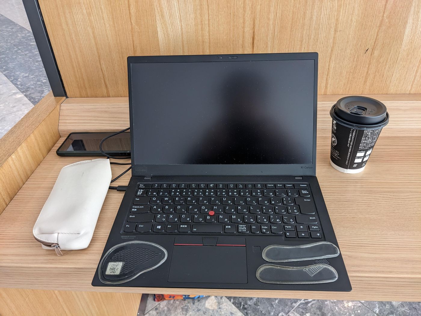 空港の電源のあるカウンターでパソコンを広げる